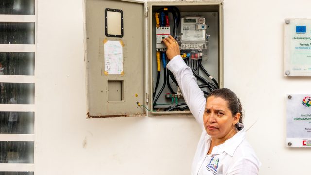 Daisy Bermeo liga o interruptor que conecta a energia fotovoltaica ao sistema de alimentação da fábrica